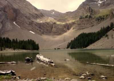 Lago Ibón de Plan con pinos, canchales y paredes rocosas